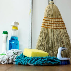 Various cleaning tools - broom, mop, sponge, brush, and disinfectant bottle.